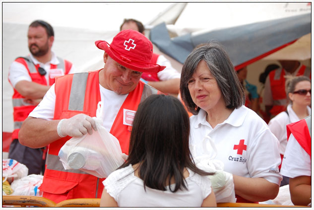 Voluntaris de la Creu Roja Espanyola distribueixen aliments a la poblaci afectada a Llorca.